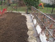 Creazione giardini: il camminamento di lastre con ghiaia porta alla colonnina dell'acqua